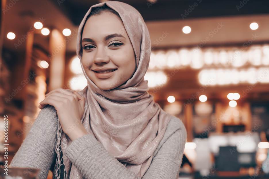 beautiful smiling Arab girl in hijab sits in cafe in oriental style Stock  Photo | Adobe Stock