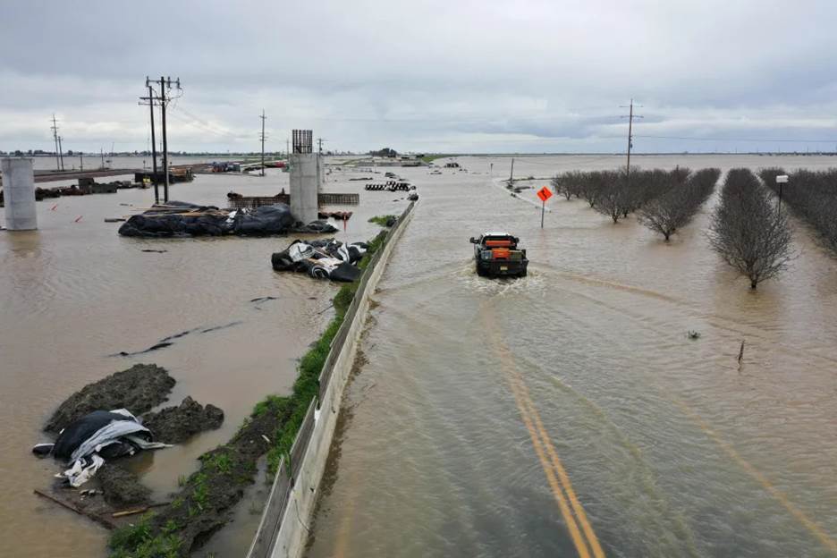 A truck drives across a flooded road near Corcoran, Calif. (Patrick T. Fallon / AFP via Getty Images file)