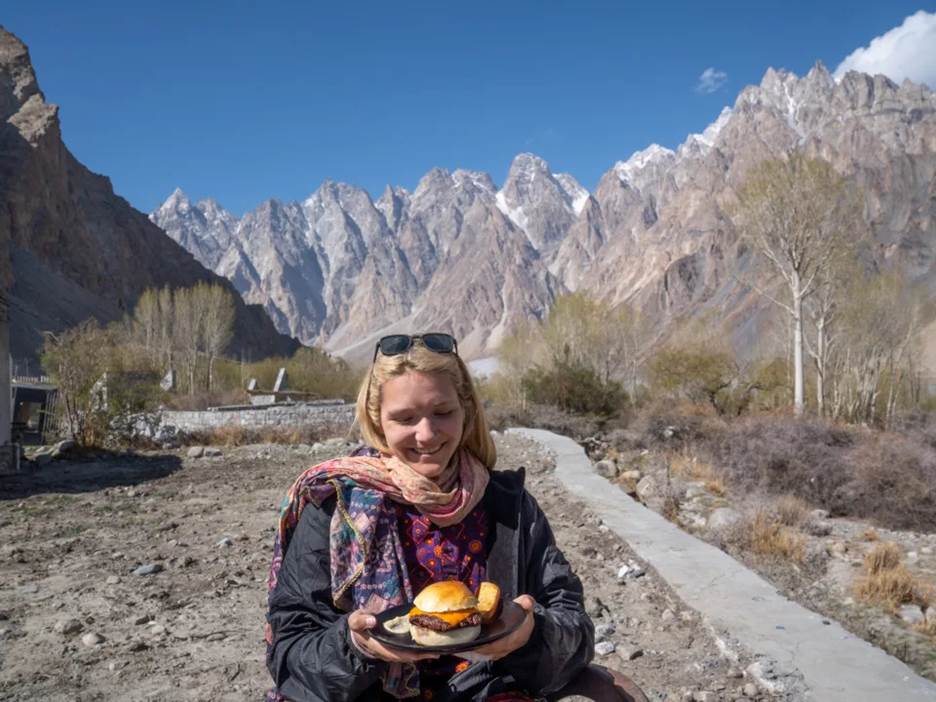 Woman eating Yak burger in Hunza Valley, Pakistan