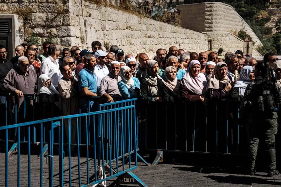 People wait in line to get past security checkpoints to attend Friday prayers in Jerusalem's Old City.