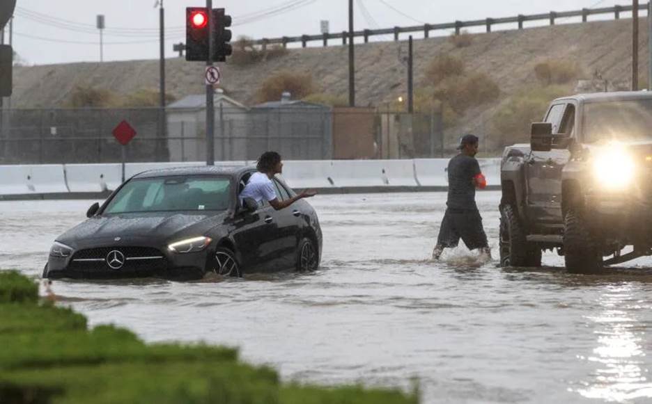 COACHELLA, CA - AUGUST 20, 2023: A driver whose car stalled out on flooded Avenue 48 asks for help from a passerby during tropical storm Hilary on August 20, 2023 in Coachella, California. (Gina Ferazzi / Los Angeles Times)