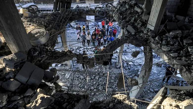People inspect the rubble of a building where the displaced Palestinian Jabalieh family were sheltering after it was hit by apparent Israeli bombardment in Rafah, in the southern Gaza Strip on January 3. - AFP/Getty Images