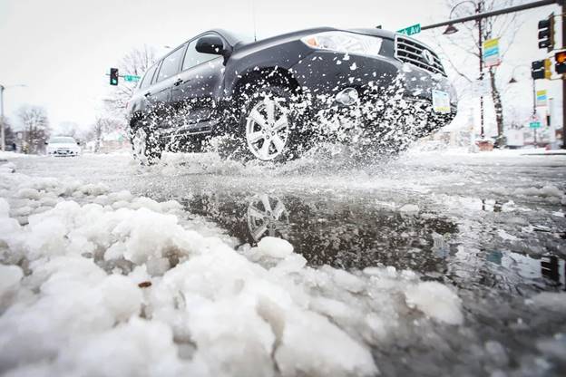 A car passes through snow on Clark Avenue after a snowstorm  (Nirmalendu Majumdar / USA Today Network)