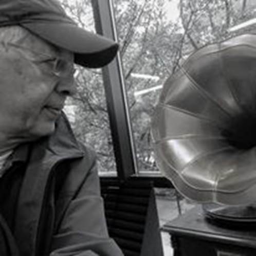 A person looking at a gramophone Description automatically generated with medium confidence