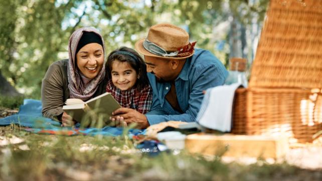 A person and person reading a book Description automatically generated with medium confidence
