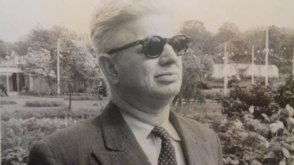 A person wearing sunglasses and a suit Description automatically generated