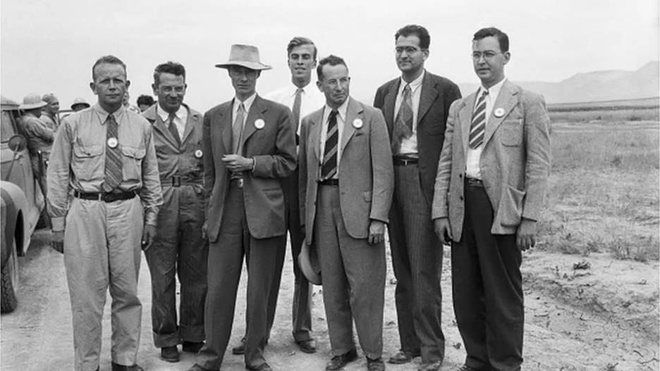 t a nuclear test site near Alamogordo, New Mexico, atomic bomb scientists measure radioactivity in seared sand particles 2 months after the explosion when newsmen saw bomb effects for the first time. Standing left to right: Dr. Kenneth.T. Bainbridge (Harvard University); Joseph G. Hoffman, (Buffalo, NY); Dr. J.R. Oppenheimer, Director of Los Alamos Atomic Bomb Project; Dr. L.H. Hempelman, (Washington University in St. Louis); Dr. R.F. Bacher (Cornell University); Dr. V.W. Weisskopf, (University of Rochester); and Dr. Richard W. Dodson (California). | Location: Near Alamogordo, New Mexico.