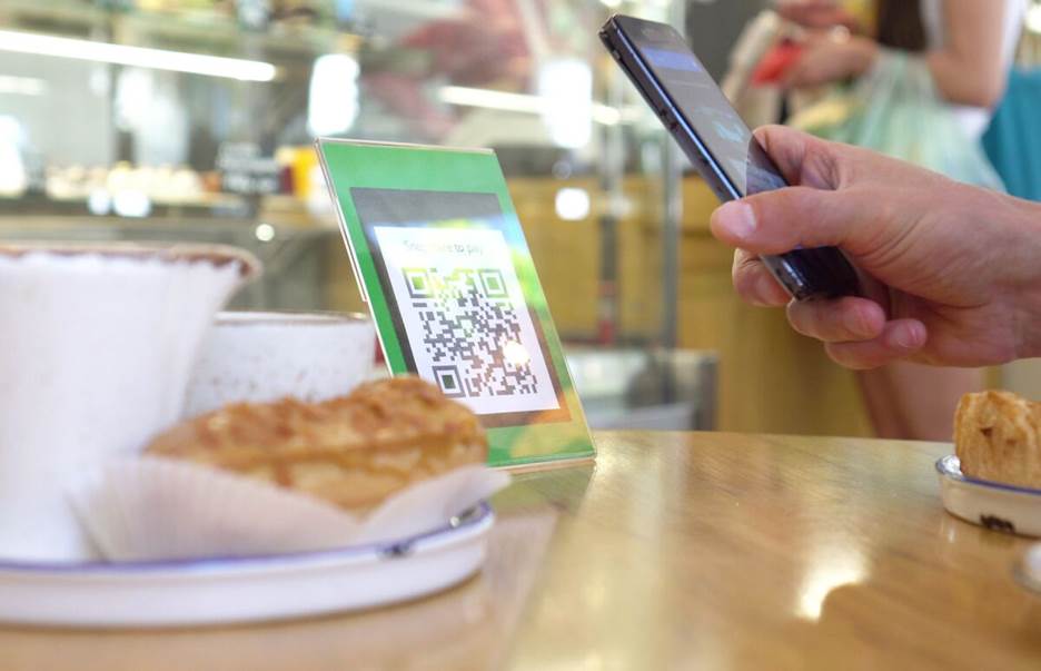 someone scanning a QR code at a coffeeshop