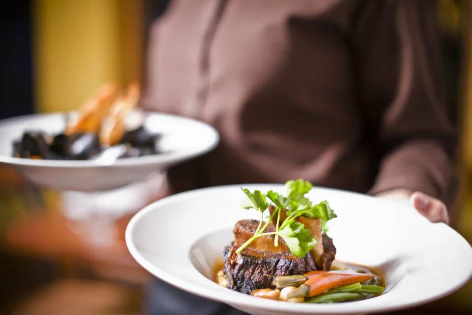 A waiter holding plates of food