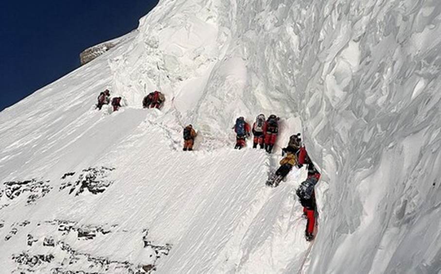 A group of people climbing a snowy mountain Description automatically generated