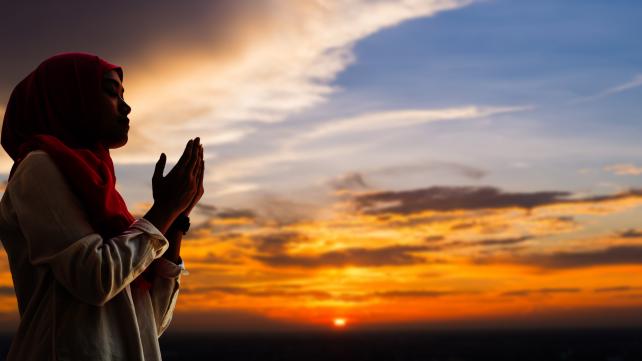 A person praying with their hands together  Description automatically generated