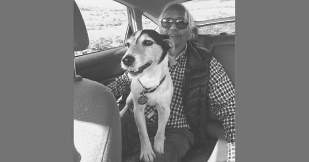 A person and dog in a car Description automatically generated