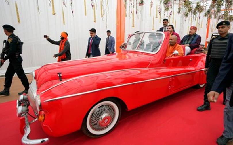 A red car with people in the back Description automatically generated