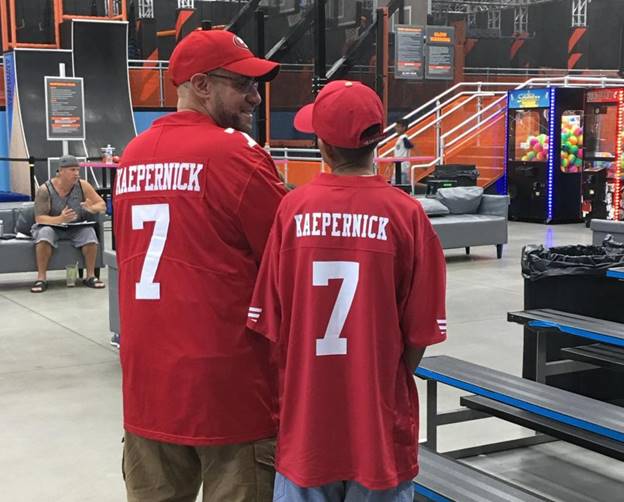 Two men wearing red jerseys Description automatically generated