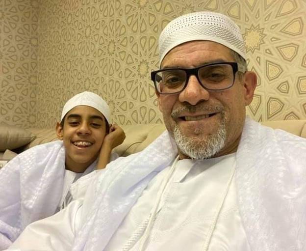 A person and child in white robes Description automatically generated