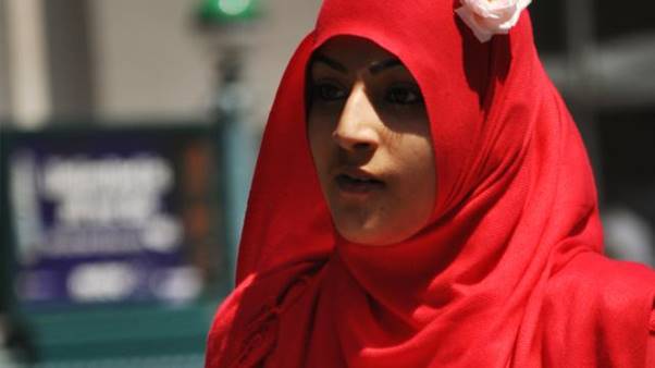 A person wearing a red head scarf Description automatically generated