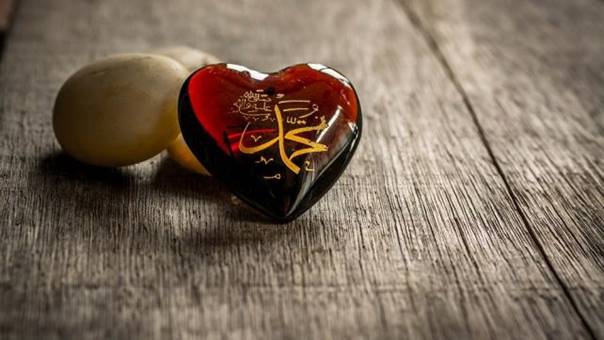 A heart shaped object on a wood surface Description automatically generated