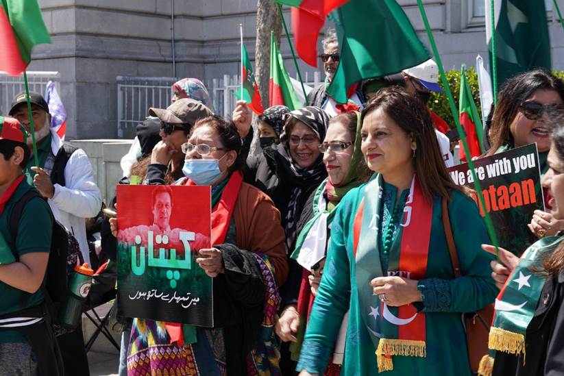 A group of people holding signs and flags Description automatically generated