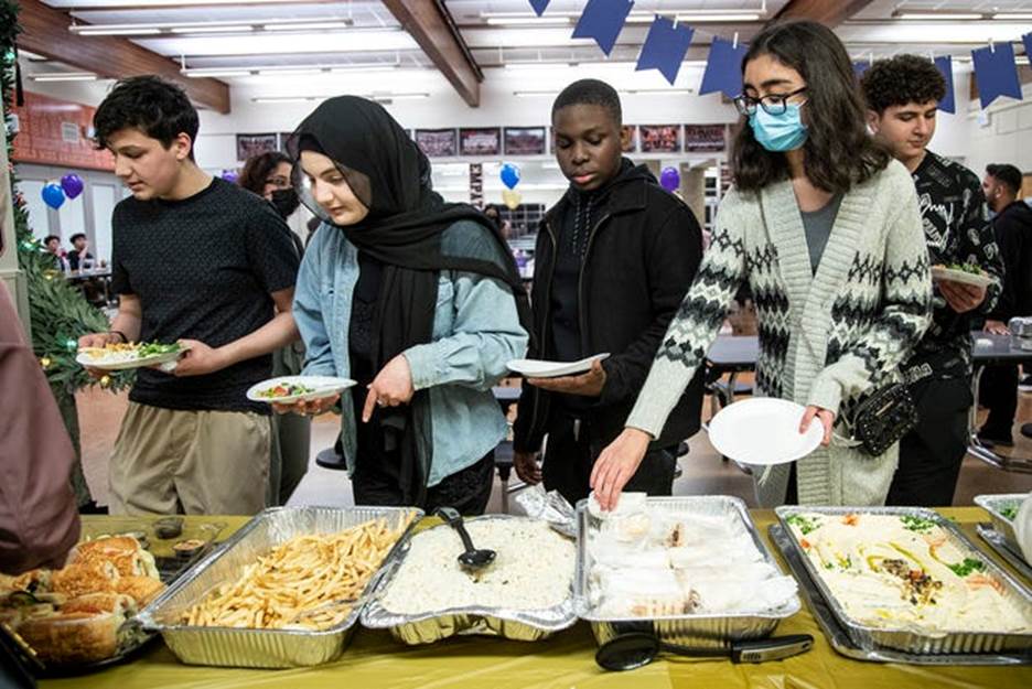 Dearborn High School students line up to get food during an iftar dinner at Dearborn High School in Dearborn on Thursday, April 21, 2022.