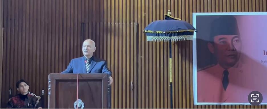 A person standing at a podium Description automatically generated