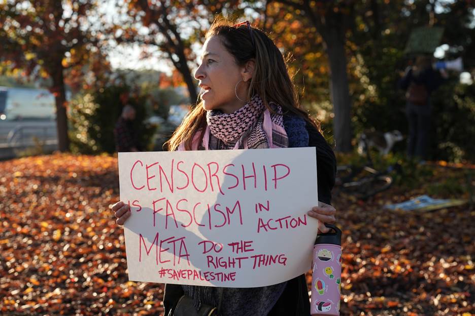 A person holding a sign Description automatically generated