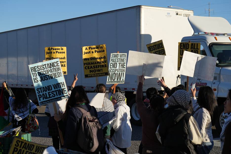 A group of people protesting with signs Description automatically generated