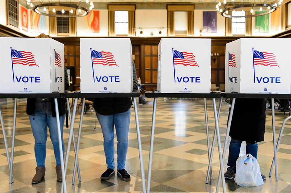 People voting boxes with flags on them Description automatically generated