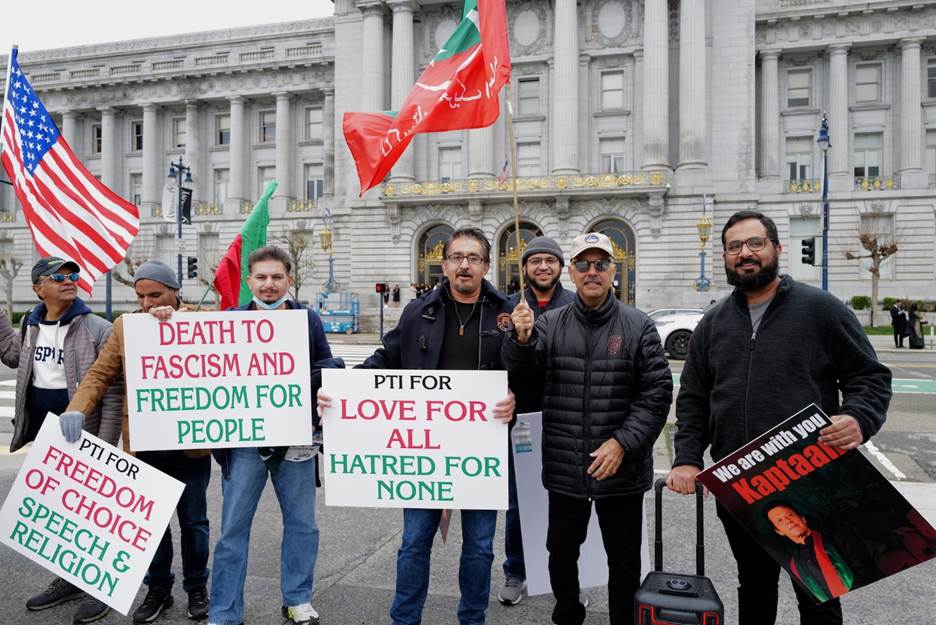 A group of people holding signs and flags  Description automatically generated with medium confidence