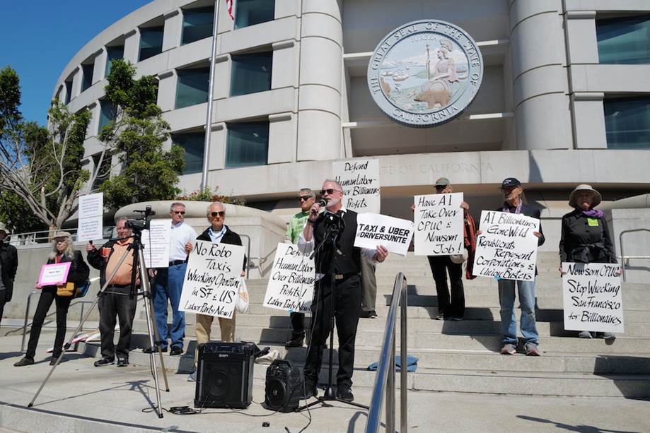 A group of people holding signs outside of a building  Description automatically generated