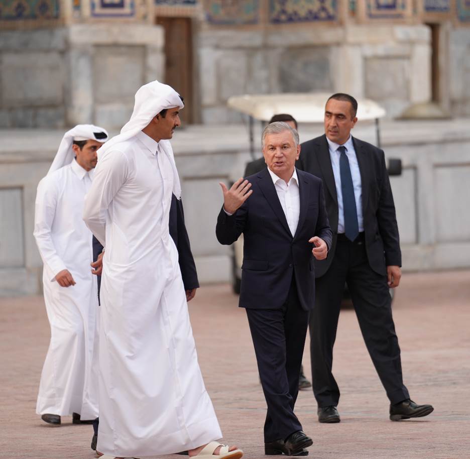 A group of men walking in a courtyard  Description automatically generated with low confidence