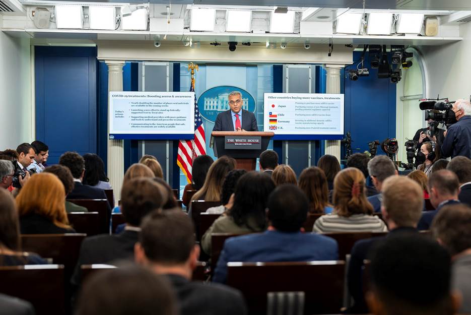 A person standing at a podium with a crowd of people in the background  Description automatically generated with low confidence