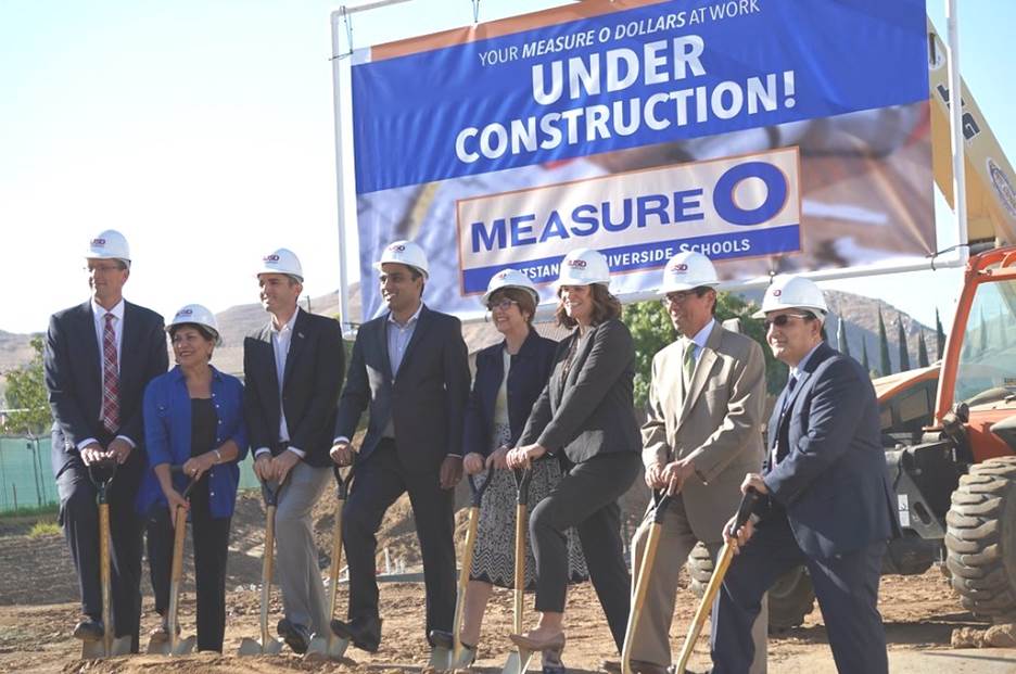 A group of people wearing hard hats holding shovels  Description automatically generated with medium confidence