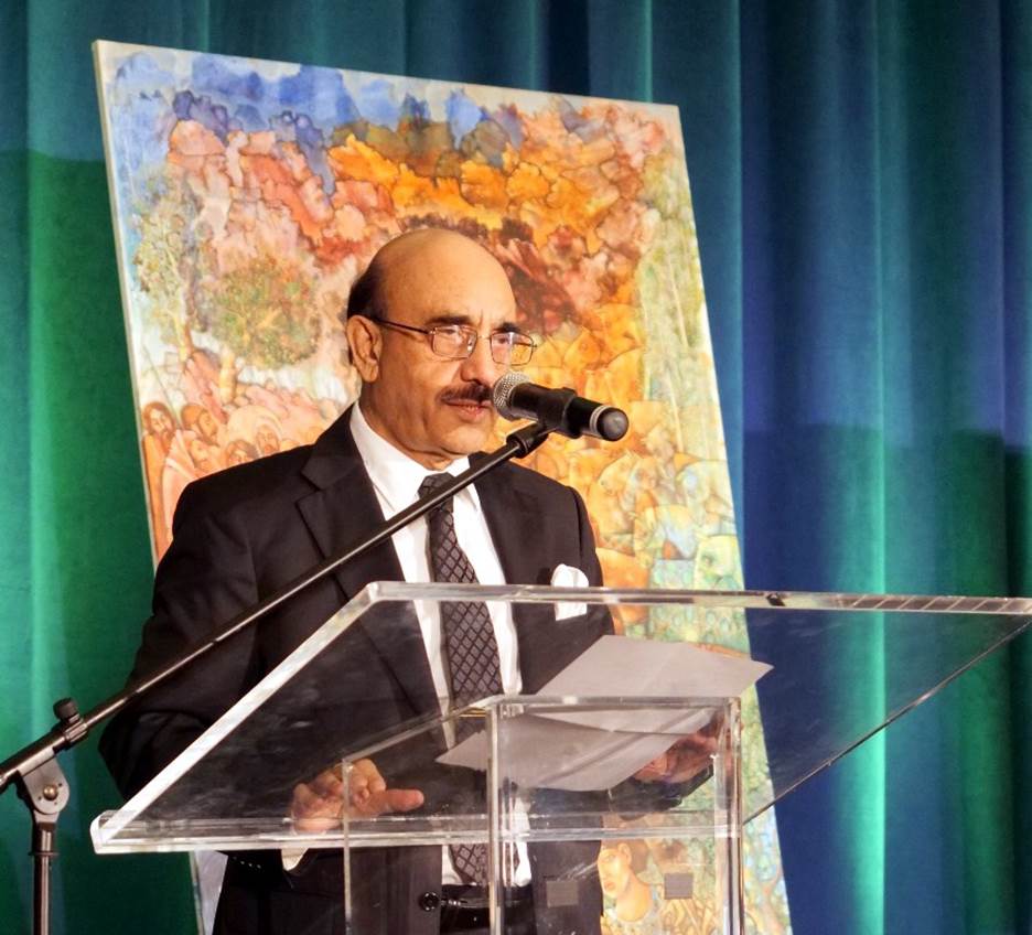 A person standing at a podium with a microphone Description automatically generated