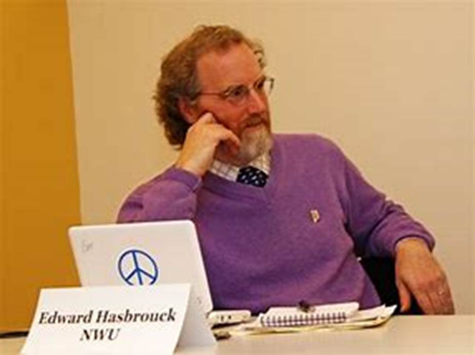 A person sitting at a desk with a computer Description automatically generated