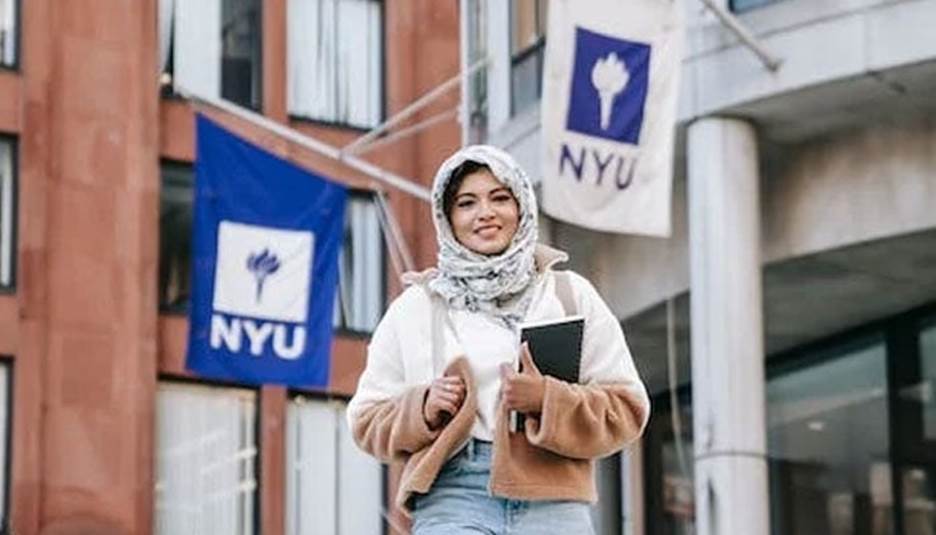 A representational image of a student standing before a universitys building. — Pexels