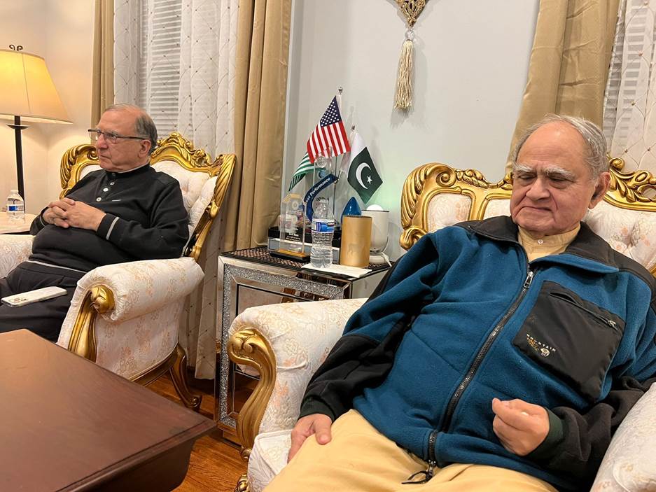 Two men sitting in chairs Description automatically generated