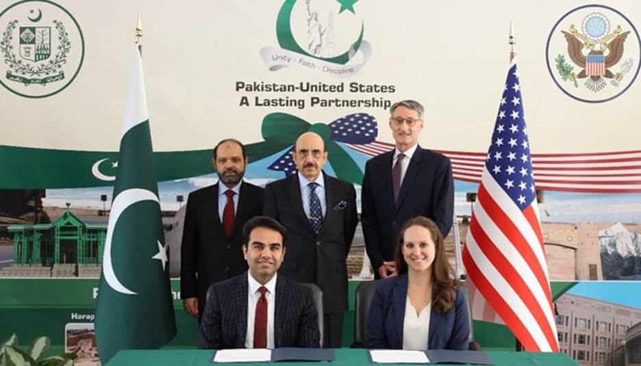Ambassador Masood Khan (centre) and Jason Donovan witness the signing of the agreement between Pakistan and US. — Twitter/@PakinUSA