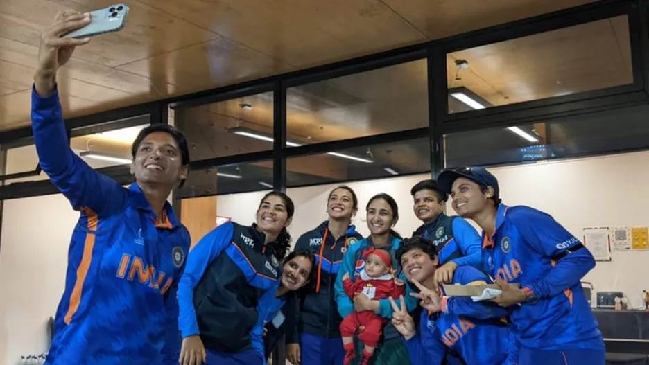 Players of the Indian women's cricket team huddled take a photo with Pakistani skipper Bismah Maroof's baby