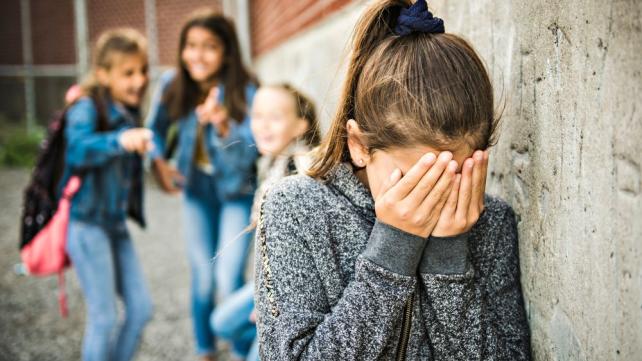 A child covering her face with her hands Description automatically generated