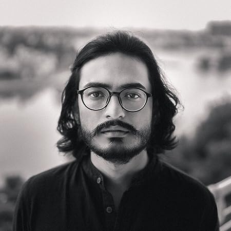 A person with long hair and beard wearing glasses Description automatically generated