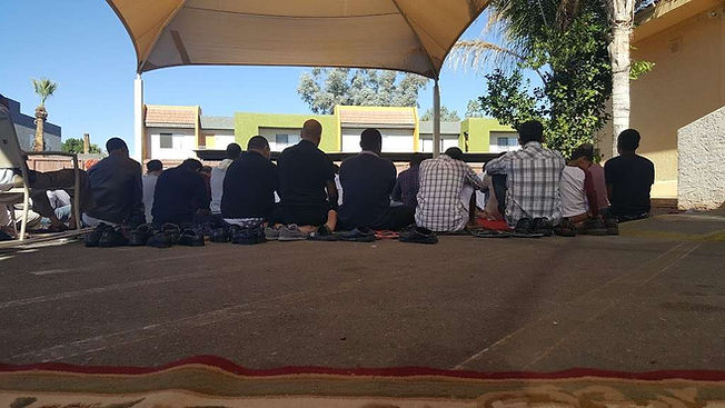 A group of people sitting under a canopy  Description automatically generated