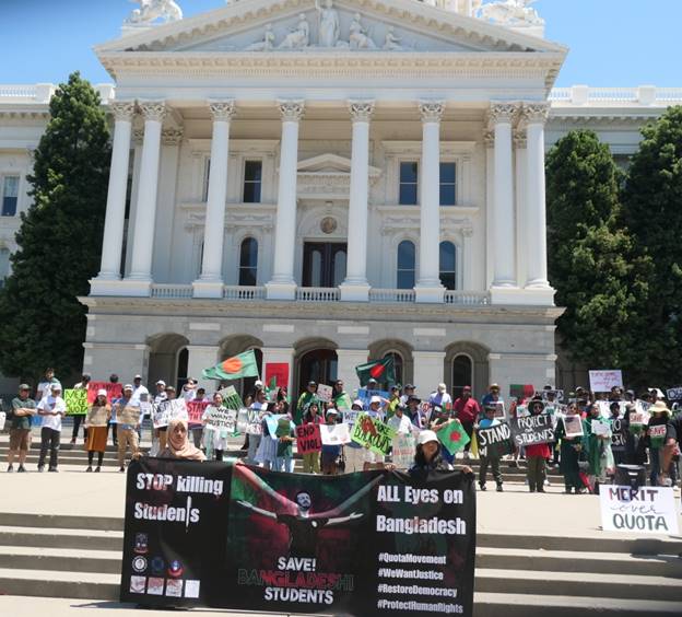 A group of people protesting in front of a white building Description automatically generated
