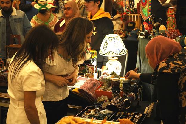 A group of women at a market Description automatically generated