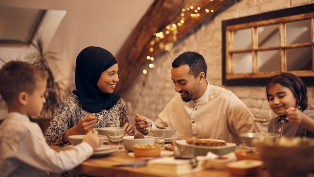 A group of people eating at a table Description automatically generated
