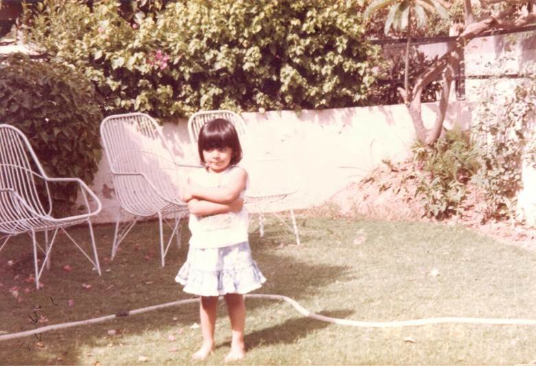A child standing in a yard Description automatically generated