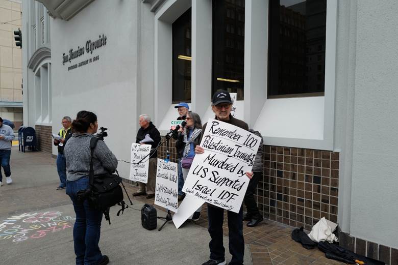 A group of people holding signs  Description automatically generated