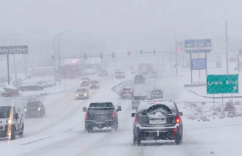 Several dozen cars on a snowy road.