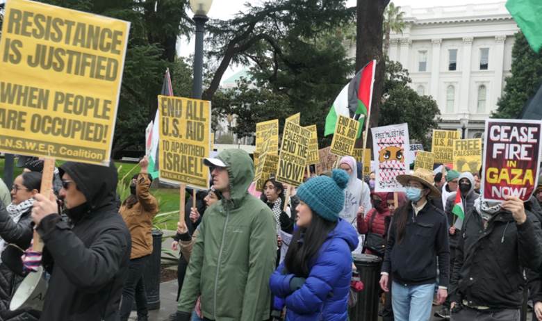 A group of people holding signs  Description automatically generated