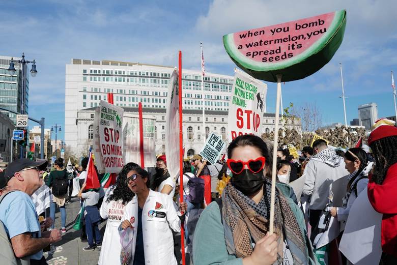 A group of people protesting in a street  Description automatically generated