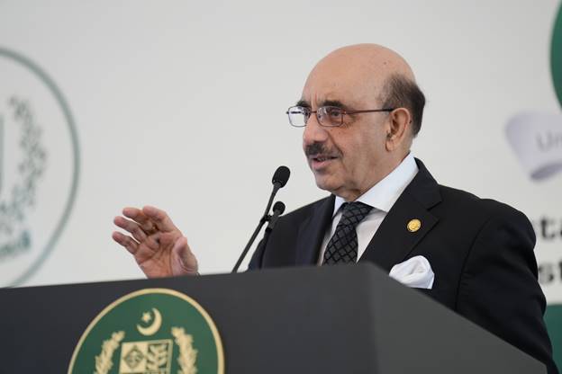 A person in a suit and tie speaking at a podium Description automatically generated